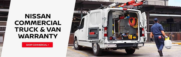 A white Nissan construction truck with the tailgate doors open and a person with a tank