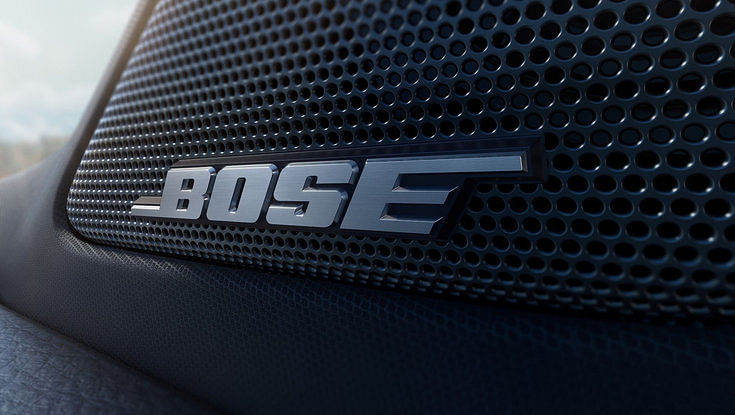 A close-up of the Bose logo on a car's speaker grille.