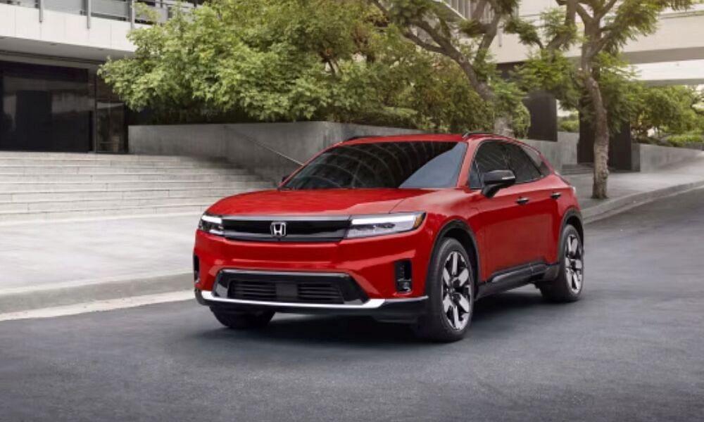 new red honda prologue driving on the street