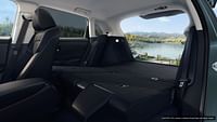 Folded rear seats in Nordic Forest Pearl Honda HR-V EX-L 2023, open trunk. Lake in background