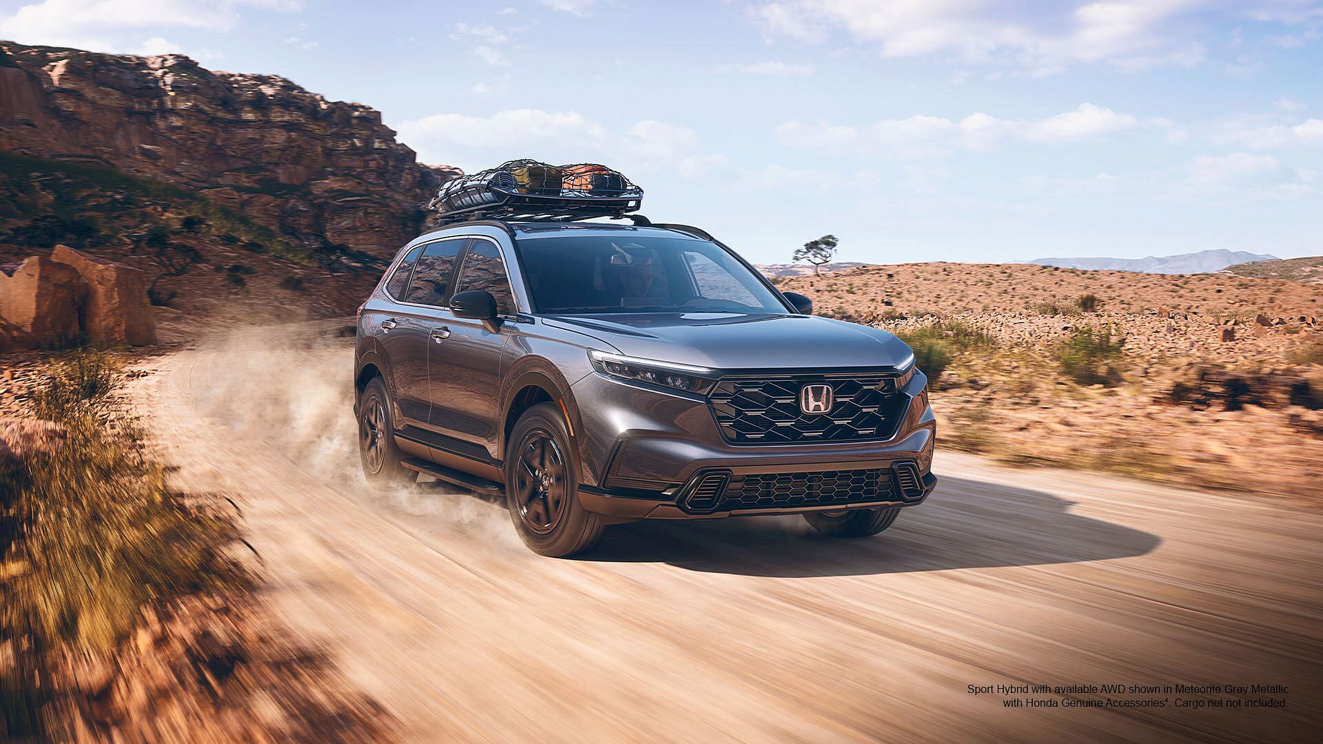 A sporty Honda 2023 hybrid with available AWD shown in Meteorite Gray Mettalic with original Honda accessories drives through the savannah.