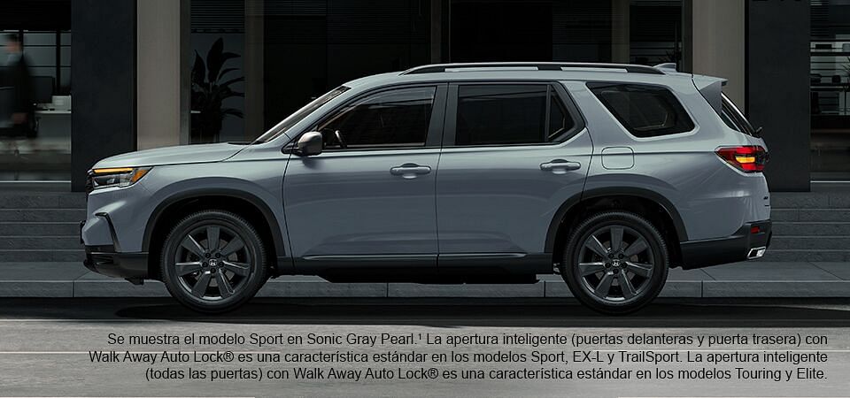 2023 Honda Pilot Sport se muestra en Sonic Gray Pearl con barras transversales de accesorios de pie junto al edificio