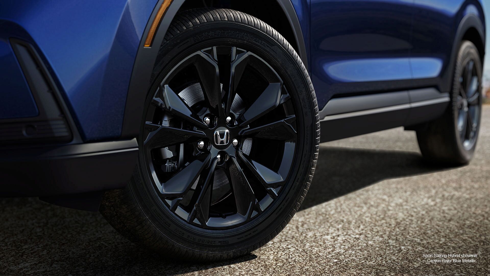 A wheel of Canyon river blue metallic honda 2023 sport touring hybrid.