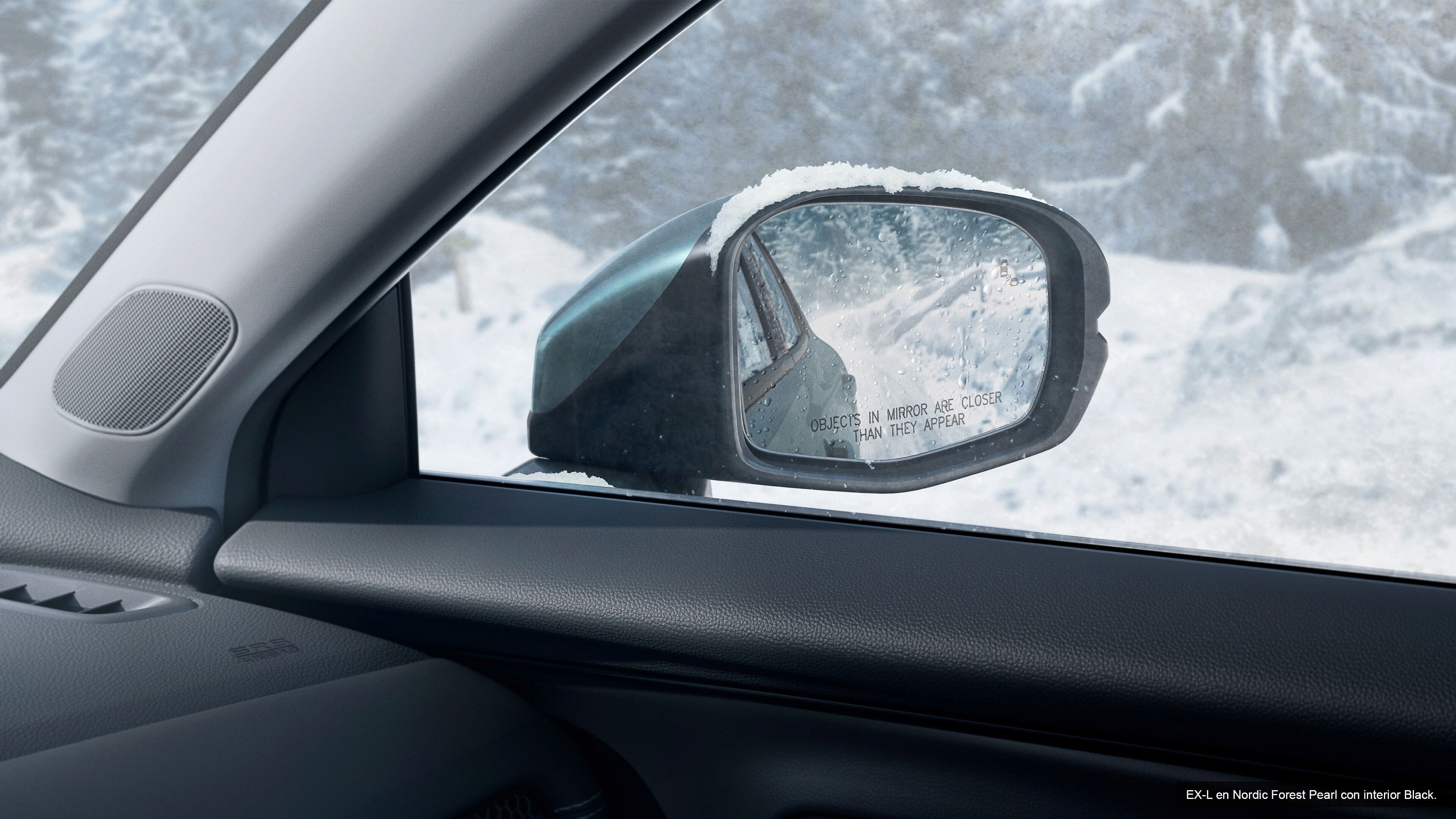 Espejo izquierdo en Honda HR-V EX-L 2023 Nordic Forest Pearl con interior negro. Bosque de invierno en el fondo