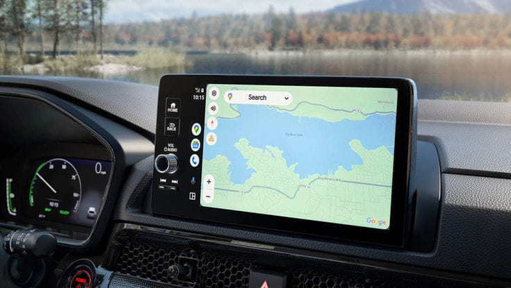 The car's infotainment screen displaying a Google Maps navigation view of a lake.