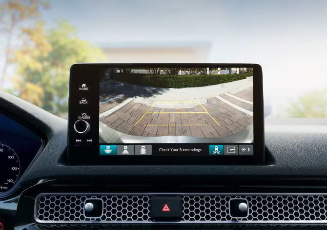 Central touchscreen display of the 2025 Honda Civic Hybrid showing the multi-angle rearview camera assisting with parking.
