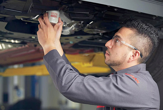 A service technician screwing in a new oil filter