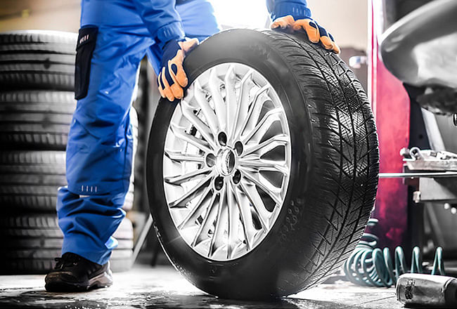 A serviceman holding a new wheel