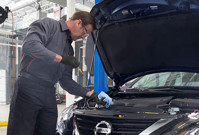 A man checks vehicle oil level