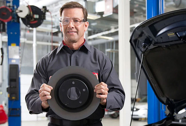 Car mechanic holding a brake disc