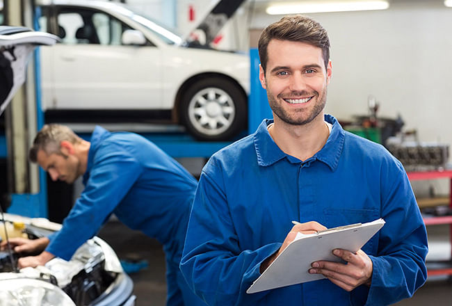 A smiling service technician holding checklist