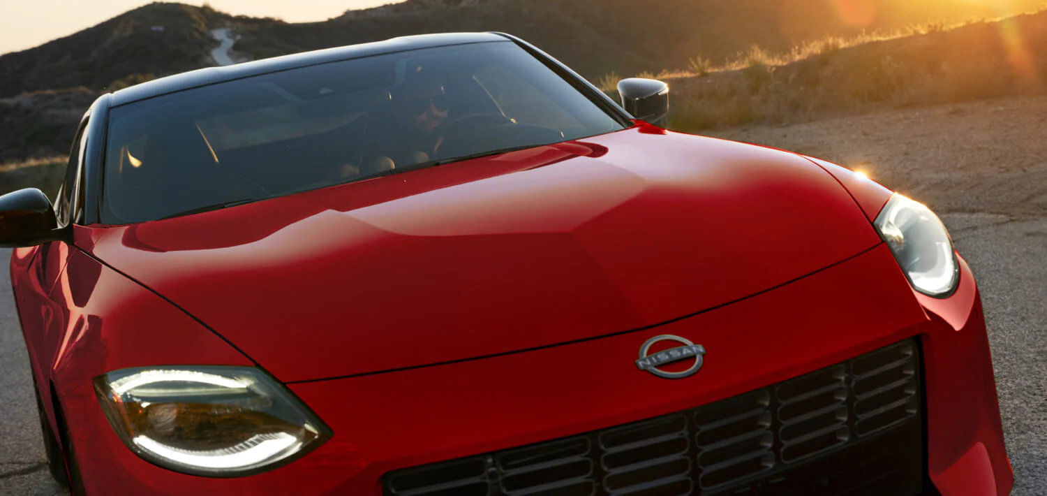 A close-up of the 400-horsepower VR30 Twin-Turbo V6 engine under the iconic hood bulge of the 2026 Nissan Z.