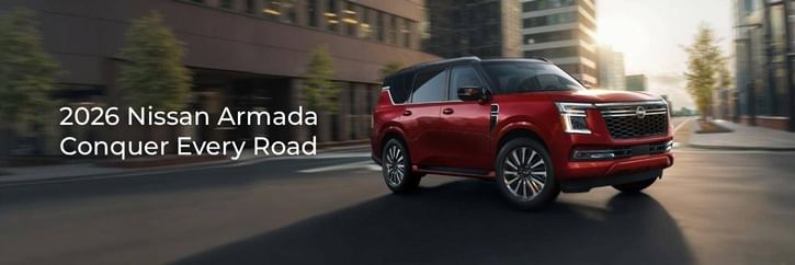 A sleek red 2026 Nissan Armada parked on an urban street, showcasing its luxurious design and modern features against a city backdrop.