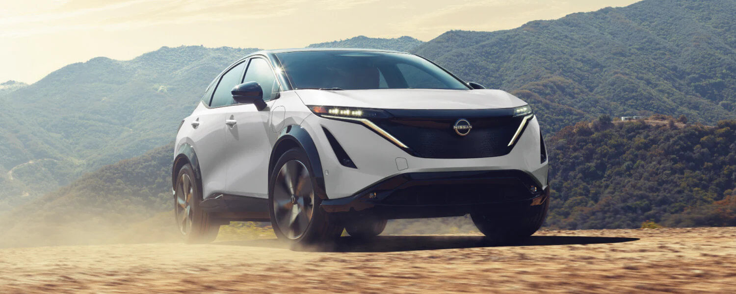 Front view of the 2025 Nissan ARIYA showcasing its super-thin LED headlights and illuminated front blade design.