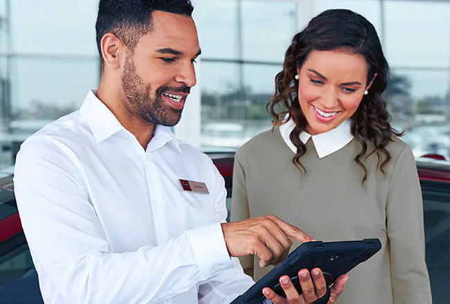 A man and a woman look at the tablet screen