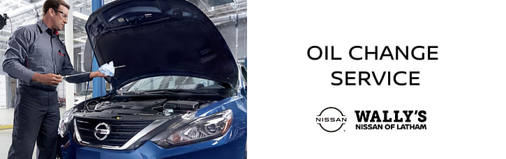 On the left a service technician checking oil level in a blue nissan, on the right text OIL CHANGE SERVICE below Wally's Nissan of Latham logo on the white background