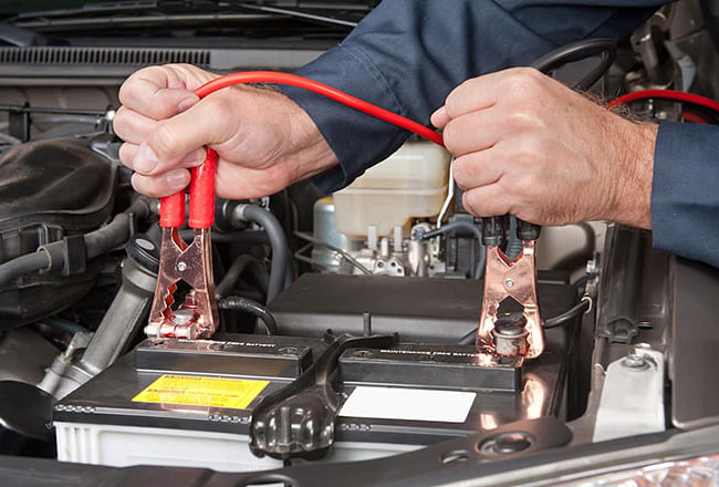 A service technician connecting the batteries' clamps.