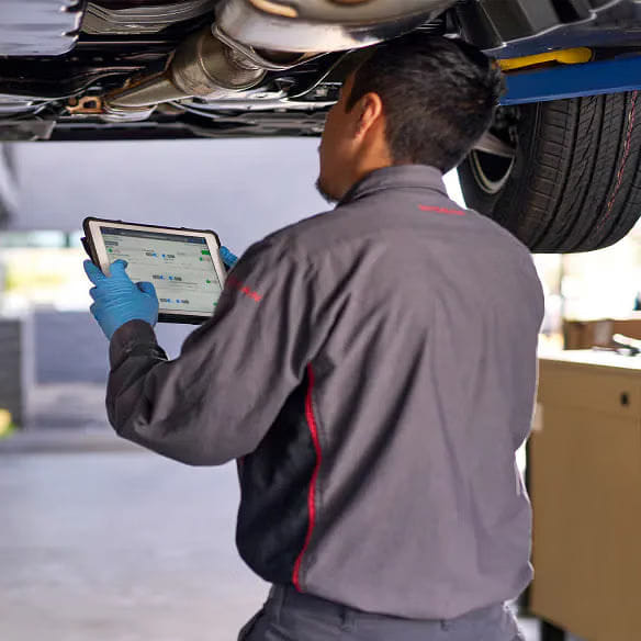 Nissan technician inspecting a vehicle