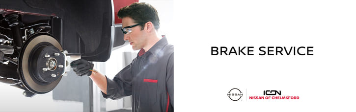 Un banner de servicio de frenos en Icon Nissan of Chelmsford con un mecánico trabajando en el rotor de freno de un auto.