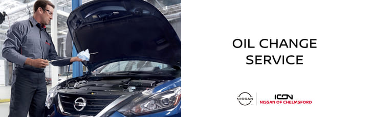 Un banner de servicio de cambio de aceite en Icon Nissan of Chelmsford con un mecánico revisando el nivel de aceite de un auto.