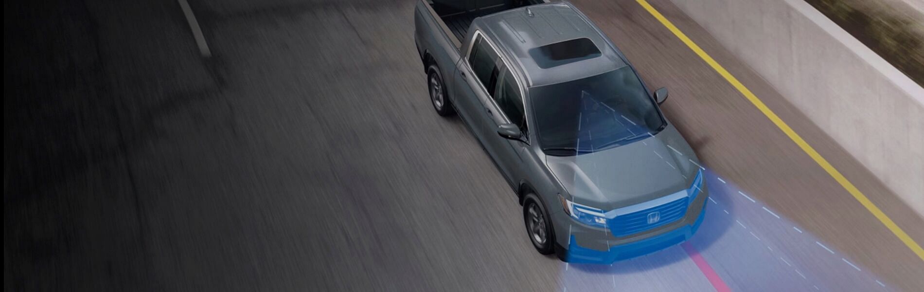 An aerial view of the new gray Honda 2023 Ridgeline driving on the highway