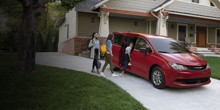 2025 Chrysler Voyager parked in the driveway and family getting into it.