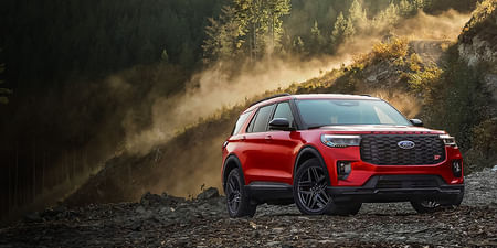 2025 Ford Explorer parked at an angle on gravel near a forrest.