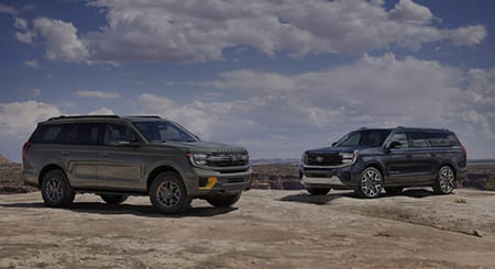 Two 2025 Ford Expedition parked on a rocky outcrop.