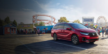 A red 2026 Odyssey parked on a wooden pier of an amusement park.