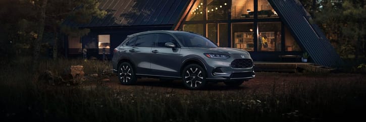 2027 Honda HR-V EX-L in Nordic Forest Pearl three quarter view parked in front of a cabin (Subcompact Crossover SUV).