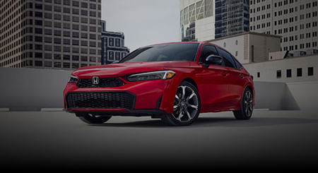 3/4 front view of red 2026 Civic Sedan parked in an empty rooftop parkade.