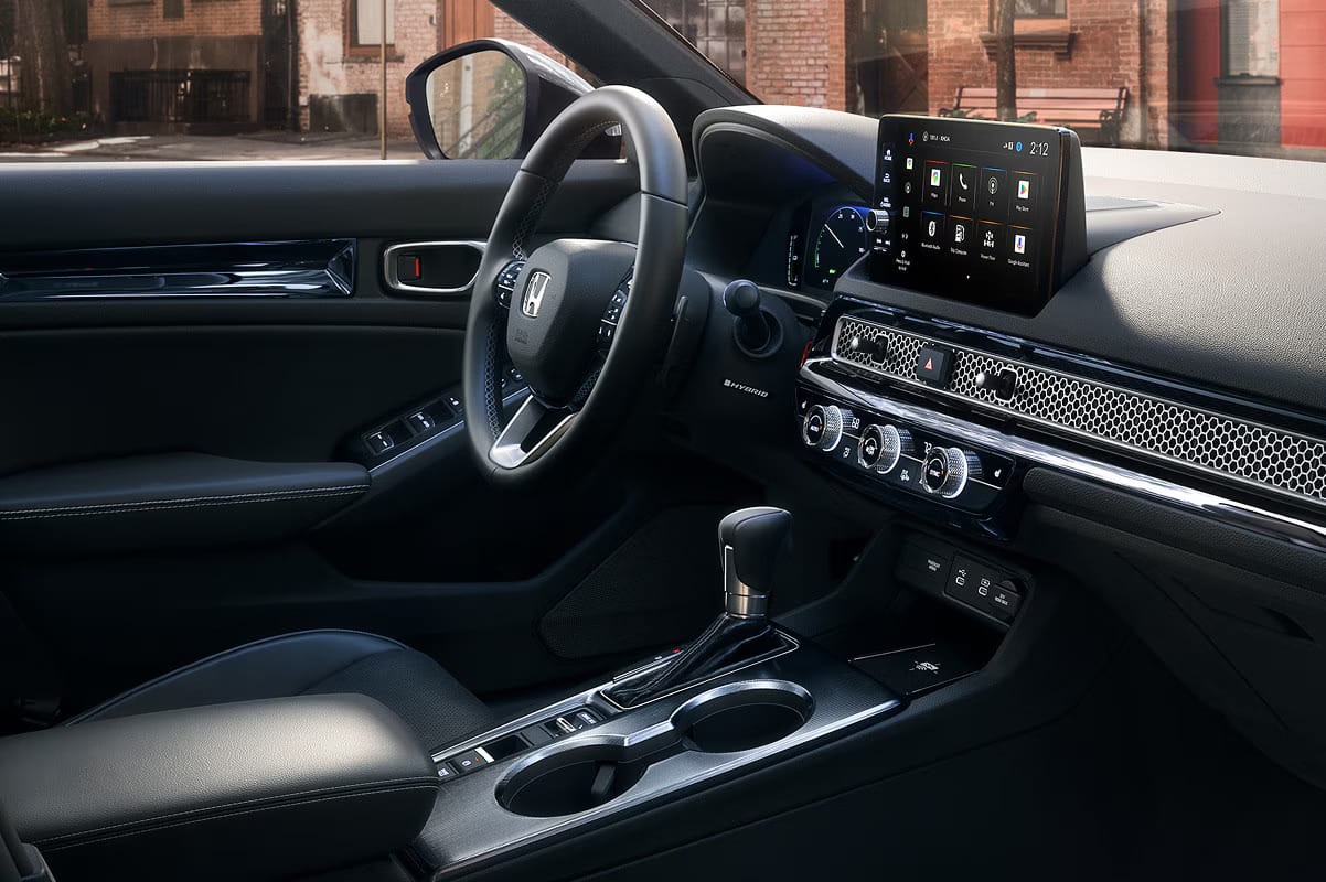 2026 Honda Civic Sedan Hybrid interior with modern dashboard, touchscreen display, and leather seats. Features include a steering wheel, gear shift, and climate controls.