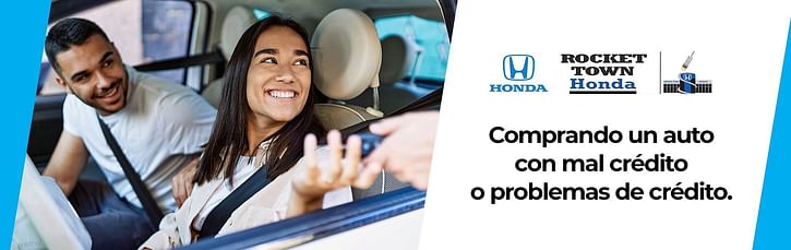 Dos personas sonriendo sentadas en un coche y recibiendo las llaves del coche