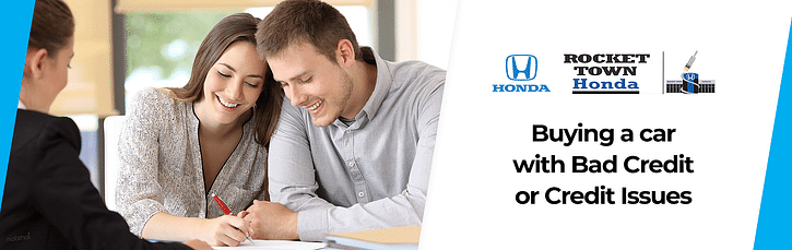 Two people sign the document and smile while sitting opposite the consultant