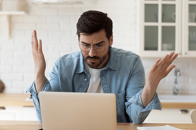 Surprised man sitting in front of laptop