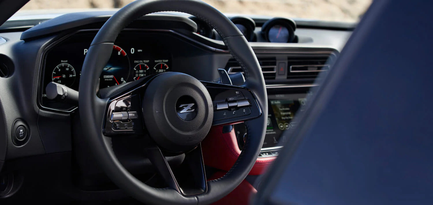 Close-up of the 2026 Nissan Z's GT-R-inspired steering wheel with the classic Z logo in the center.