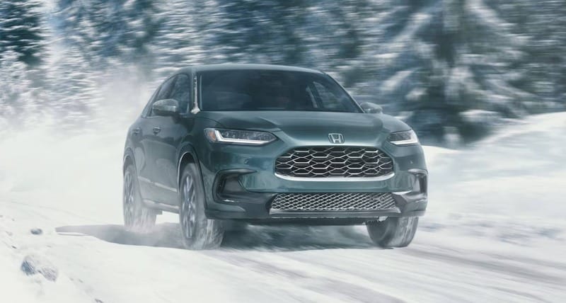 The 2026 HR-V in Nordic Forest Pearl driving in a snow road