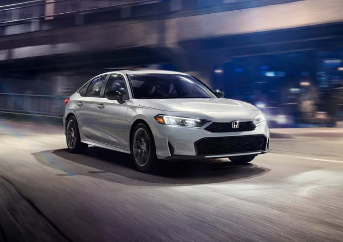 Solar Silver Metallic 2025 Honda Civic Sport Touring Hybrid showcasing its LED headlights and sporty front fascia.