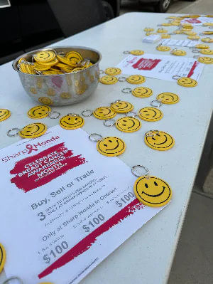 Table with breast cancer awareness flyers and many smiley face keychains.