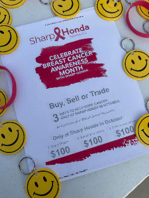 Flyer for Sharp Honda's 'Celebrate Breast Cancer Awareness Month' surrounded by smiley face keychains.