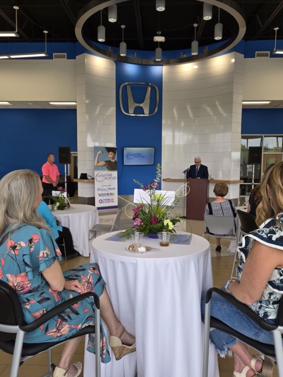 Audience at 'Everything Woman' Awards Banquet; speaker at podium, Honda logo visible.