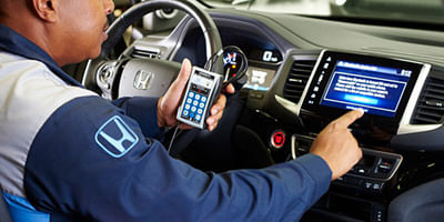 Mechanic performing Honda multi-point inspection