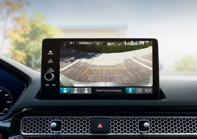 Central touchscreen display of the 2025 Honda Civic Hybrid showing the multi-angle rearview camera assisting with parking.