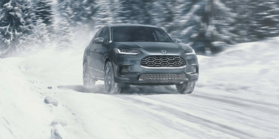 2027 Honda HR-V EX-L in Nordic Forest Pearl front view driving on a snowy road (Subcompact Crossover SUV).