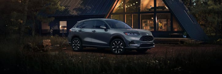 2027 Honda HR-V EX-L in Nordic Forest Pearl three quarter view parked in front of a cabin (Subcompact Crossover SUV).
