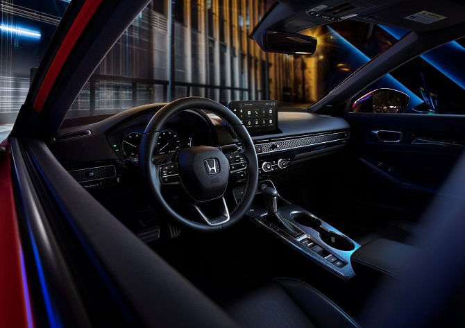 View of the 2025 Honda Civic Hybrid's steering wheel featuring paddle shifters and deceleration control selectors.