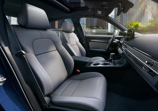 Interior view of the 2025 Honda Civic Hybrid Sport Touring with gray leather-trimmed seats and a modern, ergonomic dashboard.
