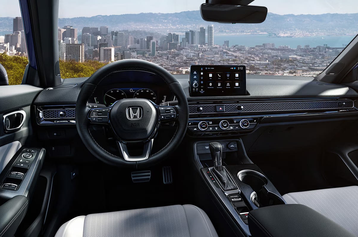 2026 Honda Civic Sedan interior with a sleek design, showcasing a digital dashboard, touchscreen, and steering wheel. City skyline and bay visible through the windshield.