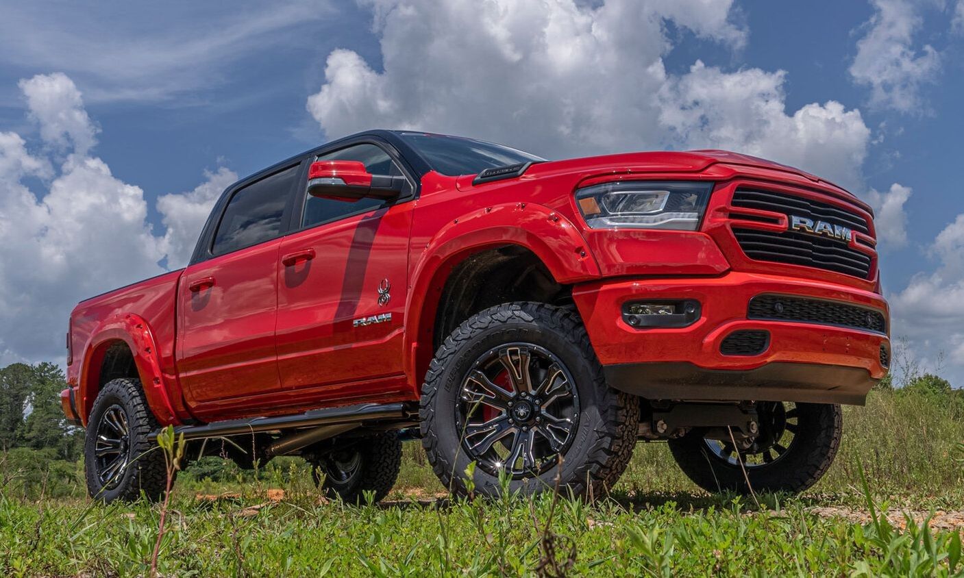 RAM 1500 Black Widow Edition truck parked in a meadow, showcasing its rugged design ideal for outdoor adventures.