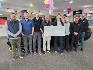 Group of Tri City Cars employees presenting a donation check to representatives from Red Cross Disaster Relief.